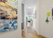 Thumbnail 9 of 48 - a hallway with paintings and a clock on the wall