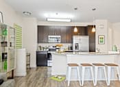 Thumbnail 1 of 48 - a kitchen with a large island with three stools in front of it
