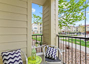 Thumbnail 20 of 48 - a patio with two chairs and a table with a bottle of water on it