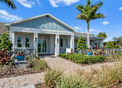 Thumbnail 44 of 46 - a house with a porch and a palm tree in front of it at Artesia at Lakewood Ranch Apartments, Bradenton, Florida
