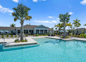 Thumbnail 28 of 46 - a large swimming pool with palm trees in front of a house at Artesia at Lakewood Ranch Apartments, Bradenton, FL, 34211
