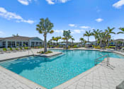 Thumbnail 30 of 46 - a large swimming pool with palm trees in front of a building at Artesia at Lakewood Ranch Apartments, Bradenton, 34211