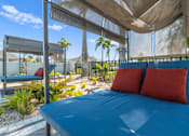 Thumbnail 33 of 46 - a patio with a blue bed and red pillows at Artesia at Lakewood Ranch Apartments, Florida