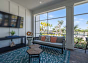 Thumbnail 26 of 46 - a living room with a couch and a television and a balcony at Artesia at Lakewood Ranch Apartments, Bradenton, FL, 34211