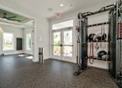 Thumbnail 20 of 46 - a home gym with weights and a door to a patio at Artesia at Lakewood Ranch Apartments, Bradenton, 34211