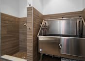 Thumbnail 24 of 46 - a large stainless steel tub in a bathroom with wooden walls and a shower at Artesia at Lakewood Ranch Apartments, Bradenton, FL