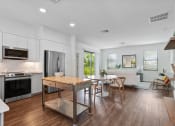Thumbnail 4 of 40 - an open kitchen and dining room with a table and chairs at Odyssey, Fort Myers, Florida
