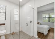 Thumbnail 15 of 40 - a bathroom with a shower and a bed at Odyssey, Fort Myers, Florida