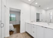 Thumbnail 14 of 40 - a white bathroom with two sinks and a mirror at Odyssey, Fort Myers, Florida