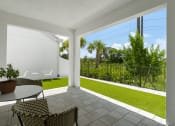Thumbnail 25 of 40 - a patio with two chairs and a table and a lawn at Odyssey, Florida, 33905