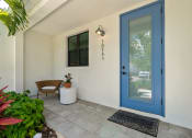 Thumbnail 27 of 40 - the front porch of a house with a blue door at Odyssey, Fort Myers, FL, 33905