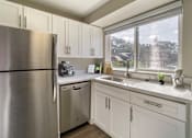 Thumbnail 1 of 23 - a kitchen with white cabinets and a large window