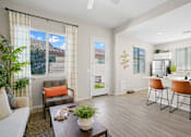 Thumbnail 6 of 37 - a living room with a dining area and a kitchen with a table and chairs at Soleil at Canyon Trails Apartments, Arizona, 85338