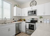 Thumbnail 1 of 37 - a kitchen with stainless steel appliances and white cabinetry at Soleil at Canyon Trails Apartments, Arizona