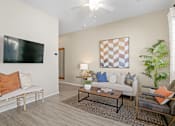 Thumbnail 5 of 37 - a living room with a couch and a table at Soleil at Canyon Trails Apartments, Goodyear