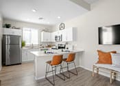 Thumbnail 3 of 37 - an open kitchen and living room with a white counter top and a stainless steel refrigerator at Soleil at Canyon Trails Apartments, Goodyear, Arizona