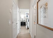 Thumbnail 7 of 37 - a hallway with white walls and white doors and a white bedroom with a white bed at Soleil at Canyon Trails Apartments, Goodyear, AZ, 85338
