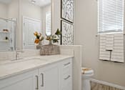 Thumbnail 9 of 37 - a bathroom with a sink and a toilet and a mirror at Soleil at Canyon Trails Apartments, Goodyear, 85338