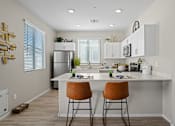 Thumbnail 2 of 37 - an open kitchen with a large island with two stools at Soleil at Canyon Trails Apartments, Arizona, 85338