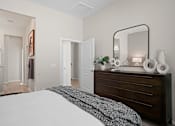 Thumbnail 19 of 37 - a bedroom with a large bed and a dresser with a mirror at Soleil at Canyon Trails Apartments, Goodyear, Arizona