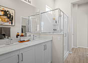 Thumbnail 21 of 37 - a bathroom with two sinks and a mirror and a shower at Soleil at Canyon Trails Apartments, Goodyear, 85338