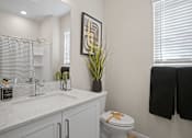 Thumbnail 25 of 37 - a bathroom with a sink and a toilet and a mirror at Soleil at Canyon Trails Apartments, Goodyear, AZ, 85338