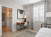 Thumbnail 24 of 37 - a bedroom with a desk and a mirror and a window at Soleil at Canyon Trails Apartments, Arizona, 85338