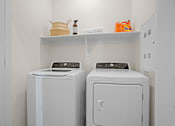 Thumbnail 27 of 37 - a washer and dryer in a white laundry room with a shelf above it at Soleil at Canyon Trails Apartments, Goodyear