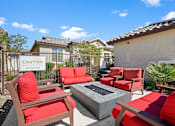Thumbnail 33 of 37 - a patio with red chairs and a fire pit at Soleil at Canyon Trails Apartments, Goodyear, 85338