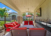 Thumbnail 34 of 37 - a covered patio with furniture and a table and chairs at Soleil at Canyon Trails Apartments, Goodyear, 85338