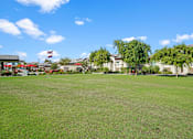 Thumbnail 36 of 37 - a large lawn with houses in the background at Soleil at Canyon Trails Apartments, Arizona