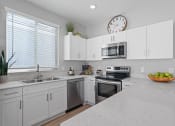 Thumbnail 1 of 43 - a large kitchen with white cabinets and a counter top at Sienna at South Mountain Apartments, Arizona
