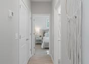 Thumbnail 8 of 43 - a long hallway with a bed and a white door at Sienna at South Mountain Apartments, Laveen, Arizona