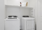 Thumbnail 13 of 43 - a small laundry room with two washes and a dryer at Sienna at South Mountain Apartments, Laveen, 85339