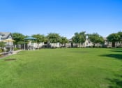 Thumbnail 39 of 43 - a large green lawn in front of a row of houses at Sienna at South Mountain Apartments, Arizona