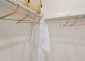 Thumbnail 28 of 43 - a closet with a white shirt hanging from a rack on the wall at Sienna at South Mountain Apartments, Laveen, AZ, 85339