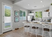 Thumbnail 18 of 43 - a kitchen with a bar and stools and a refrigerator at Sienna at South Mountain Apartments, Arizona