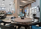 Thumbnail 29 of 65 - A poker table is surrounded by chairs in a room with a bar area in the background. at Centre Pointe Apartments, Florida, 32940