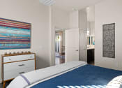 Thumbnail 9 of 33 - a bedroom with a bed and a bathroom with a sink at Olive Queen Creek Apartments, Queen Creek, AZ