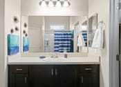 Thumbnail 11 of 33 - a bathroom with a sink and a mirror at Olive Queen Creek Apartments, Queen Creek, Arizona