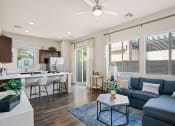 Thumbnail 5 of 33 - an open living room and kitchen with a blue couch and a coffee table at Olive Queen Creek Apartments, Queen Creek, 85142