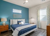 Thumbnail 8 of 33 - a blue and white bedroom with a bed and a ceiling fan at Olive Queen Creek Apartments, Arizona, 85142