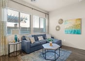 Thumbnail 6 of 33 - a living room with a blue couch and a coffee table at Olive Queen Creek Apartments, Queen Creek