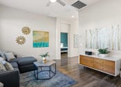 Thumbnail 7 of 33 - a living room with a couch and a coffee table at Olive Queen Creek Apartments, Queen Creek