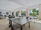Thumbnail 44 of 65 - A ping pong table is in the middle of a room with a white ceiling and a glass wall outside. at Centre Pointe Apartments, Melbourne