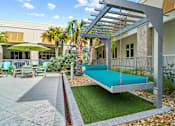 Thumbnail 56 of 65 - A patio with a swing bed and a table with chairs. at Centre Pointe Apartments, Melbourne