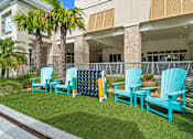 Thumbnail 59 of 65 - A row of blue chairs are arranged on a lawn. at Centre Pointe Apartments, Melbourne, FL, 32940