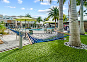 Thumbnail 57 of 65 - A pool area with a hammock and palm trees. at Centre Pointe Apartments, Florida