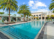 Thumbnail 48 of 65 - A large swimming pool surrounded by palm trees and lounge chairs. at Centre Pointe Apartments, Melbourne, 32940