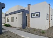 Thumbnail 19 of 33 - the front of a white house with blue trim and a sidewalk at Olive Queen Creek Apartments, Queen Creek, AZ, 85142